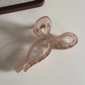 Détail de la pince à cheveux ruban rose poudré mat avec ressort en métal doré