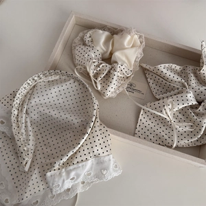 Detail of cream polka dot hair accessories set with lace trim and silk texture