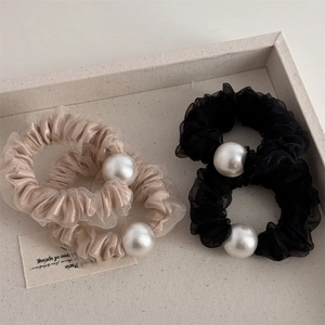 Dettaglio degli elastici per capelli in mesh velato con grandi perle finte decorative
