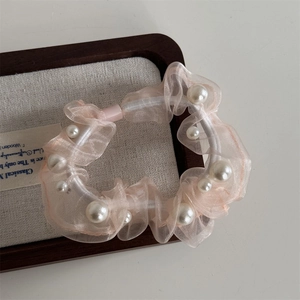 Detail of pink organza hair scrunchie with embedded pearls and high-elasticity band