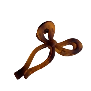 Pince à cheveux marron mat en forme de ruban avec grandes dents et lignes fluides