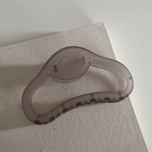 Close-up of a matte grayish purple hair claw clip with frosted texture and wavy design