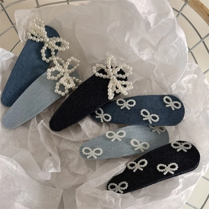 Detailansicht von sechs blauen Denim-Haarspangen mit eleganten Perlenbogen-Dekorationen