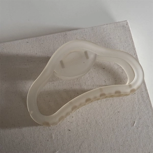 Close-up of cream matte frosted hair claw clip on textured white canvas background
