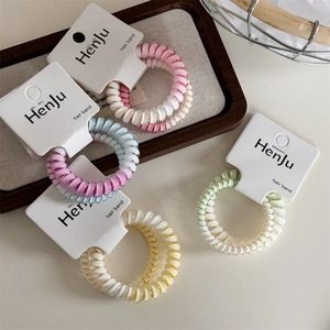 Set di elastici per capelli a spirale pastello su schede espositive dal design morbido