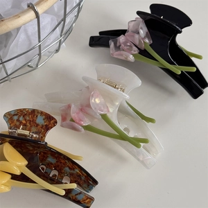 Detailed macro view of large acetate hair clips featuring 3D tulip floral decorations
