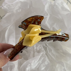 Macro shot of large acetate claw clip with yellow Calla Lily flowers and tortoise pattern