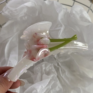 Macro detail of acetate tulip flower hair claw clip with pearlescent cream finish