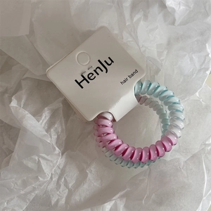 Dettaglio degli elastici per capelli a spirale rosa e blu su una scheda di supporto