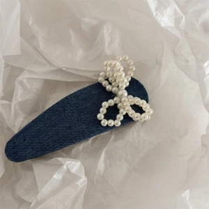 Detailansicht der Haarspange aus blauem Denim-Stoff mit eleganter weißer Perlen-Schleife