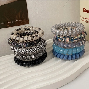 Detail of colorful spiral hair ties with checkered and floral patterns on display stand