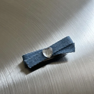 Detail of Y2K denim bow hair claw clip with heart rhinestone and textured blue fabric