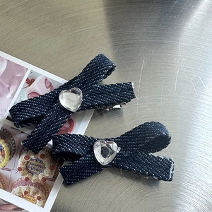 Close-up of blue denim bow hair claw clips with sparkling heart-shaped rhinestones
