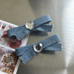 Detail of light blue denim bow hair clips with sparkling heart-shaped rhinestones