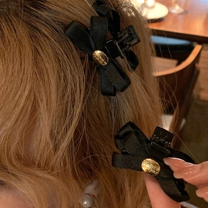 Elegante fermaglio per capelli a fiocco nero con inserto in metallo dorato inciso