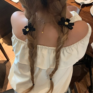 Eleganti mollette per capelli a fiocco in velluto nero con dettagli dorati su trecce