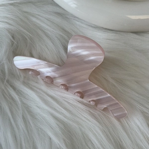Close-up of pink marbled acetate hair claw clip with smooth texture and non-slip design