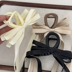 Elegant fabric ribbon bow hair claw clip with long tassels in cream, brown, and black