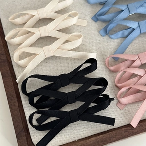 Detailed texture of multi-layered fabric ribbon bow hair clips in pastel color palette