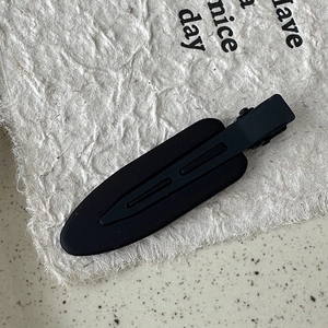 Macro view showing the matte black texture and smooth streamlined design of this hair clip