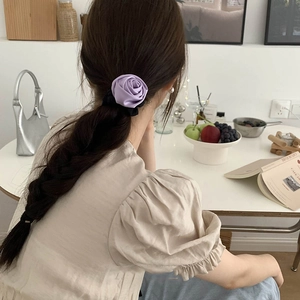 Elegant purple satin rose flower hair scrunchie shown on a low ponytail hair style
