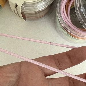 Pink high elasticity hair tie with seamless design and macro texture in a storage jar