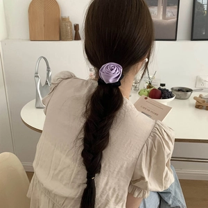 Elegant purple satin rose hair scrunchie shown on long hair for a stylish look