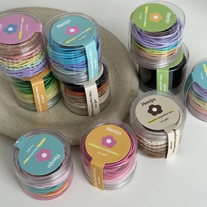 Detailed view of colorful elastic hair bands packed in a transparent cylinder container