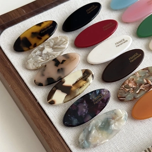 Detail view of assorted acetate oval hair clips with gold FRANCE Handmade lettering