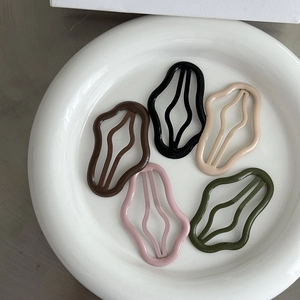 Vista dettagliata delle clip per capelli BB ondulate in cinque colori opachi su ceramica