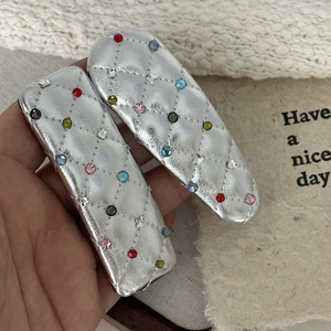 Y2K silver quilted leather hair clips with colorful crystals held in hand