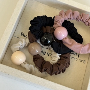 Détail de chouchous en tissu de quatre couleurs avec de grandes perles en résine polie