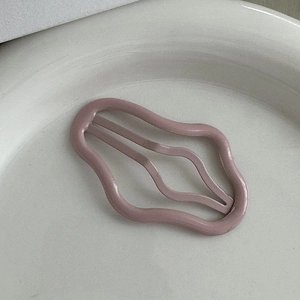 Dettaglio del fermaglio a nuvola traforato in rosa antico opaco su vassoio di ceramica
