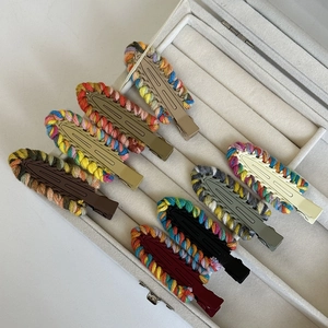 Set of eight knitted wool edge hair clips in autumn colors on a jewelry display tray