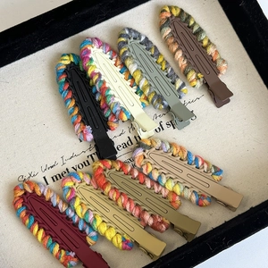 Detail of colorful hand-woven yarn duckbill hair clips with matte finish texture