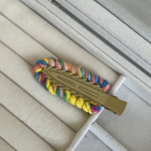 Detailed view of the woven texture and colorful yarn on the metal hair clip base
