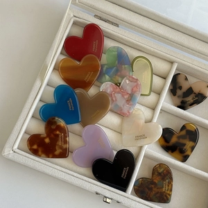 Detailed close-up of heart-shaped acrylic hair clips in various colors and patterns