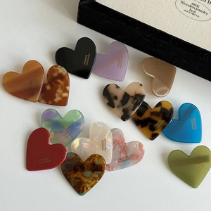 Detailed collection of 13 heart-shaped acrylic hair clips in solid colors and patterns