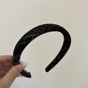 Close-up of the black and white plaid tweed fabric texture on a thick sponge headband