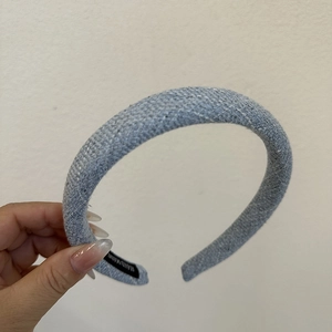 Detail of light blue woven hairband with thick sponge padding and handmade tag