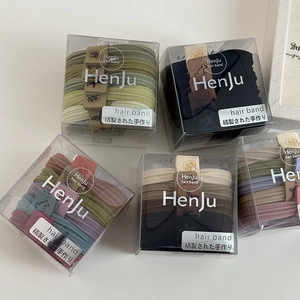Close-up of seamless elastic hair ties with cartoon charms in transparent storage boxes