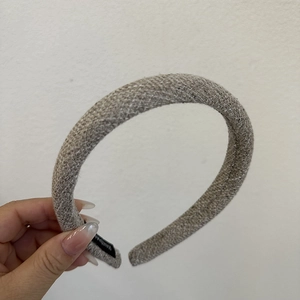 Close-up of grey tweed striped sponge headband featuring a black handmade label tag