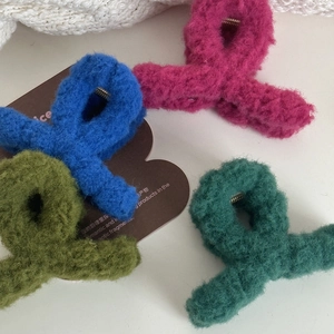 Detailed macro view of four colorful plush hair claws with soft felt texture