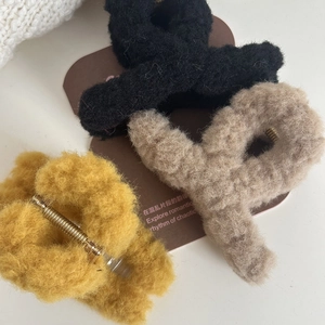 Three plush faux fur hair claw clips in black, beige, and yellow for autumn fashion styling