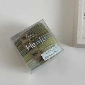 Close-up of Morandi green high-elastic hair bands with textured ribbing in a transparent gift box