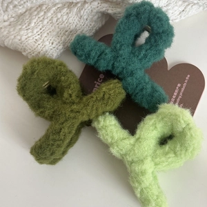 Detailed view of plush cross hair claws in three shades of green with soft faux fur texture
