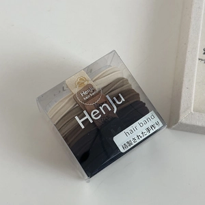 Detail of high-elasticity hair ties in earthy tones inside a clear minimalist box