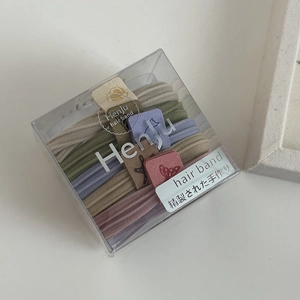 Detailed view of seamless elastic hair bands in Morandi colors inside a transparent box