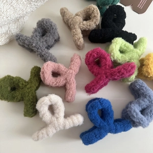 Flat lay of colorful plush hair claws in various shades on minimalist background
