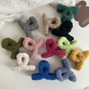 Detailed overhead view of twelve assorted fuzzy faux fur hair claw clips in autumn colors